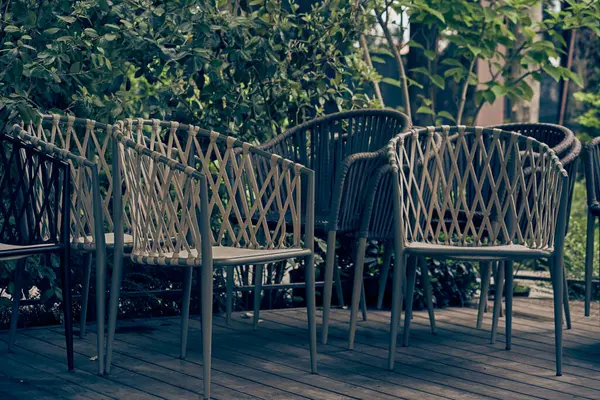 Açık havada, yeşil çalıların arka planında hasır plastik sandalyeler. Kafe kapalı, sabahleyin hiç ziyaretçi olmaz. Kopyalayacak yer de var. Yüksek kalite fotoğraf