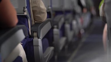 Bir uçağın rahat kabinindeki yolcu koltukları arasındaki geçişin prizmasına odaklanmamış bir görüntü. Yüksek kalite 4k görüntü