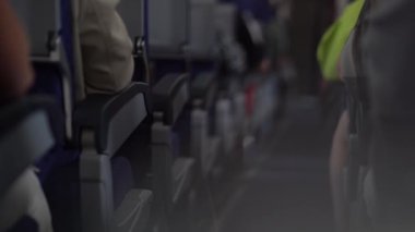 Bir uçağın rahat kabininde yolcu koltukları arasında koridor boyunca oturan insanların yansıması olan bir mercekten görüntü. Yüksek kalite 4k görüntü