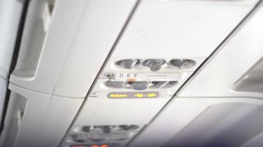 Bir yolcu uçağının tavanında oksijen maskesi gibi güvenlik elemanlarının bulunduğu düğmeler ve anahtarlar bulundu. Kopyalayacak yer de var. Yüksek kalite 4k görüntü
