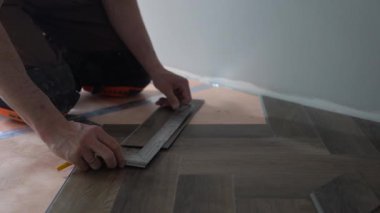 Profesyonel kuvars vinil döşeme, döşeme kaplamalarının çalışma akışı. Tanınmayan bir işçi yere kuvars plağı serer. Yüksek kalite 4k görüntü