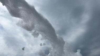 Köpük partisi, gökyüzünün arka planında bulutlu köpük topu. Köpük köpüğü dans pistini kaplıyor, müzik ve sabun köpükleri neşeli bir atmosfer yaratıyor. Yüksek kalite 4k görüntü