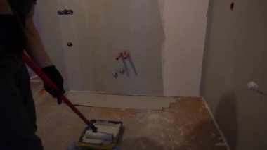 Tamir konsepti. İç tasarım için inşaat malzemeleri. Oda dekorasyonu, daire. Elle boyanmış duvarlar ve gri bir boya silindiri. Yüksek kalite 4k görüntü