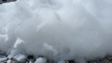 Köpük partisi için beyaz köpük. Plaj köpükten oluşan köpük veya köpük katmanıyla kaplıdır. Tatilde bir tatil. Yüksek kalite 4k görüntü