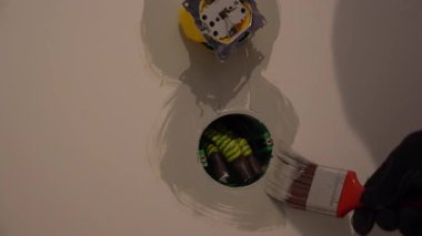 Elektrik bağlantısı ve plastik prizlerin onarımı ve kurulumu için hazırlık. Duvarları fırçayla boyuyorum, plastik soketler için deliklerin yakınına. Yüksek kalite 4k görüntü