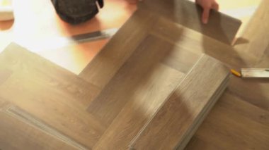 Bir apartman dairesinde ya da evde yılbaşı ağacı şeklinde kuvars vinil döşeme döşemesi. Laminat veya kuvars vinil kaplama koyu renk ve ahşap desenli. Yüksek kalite 4k görüntü