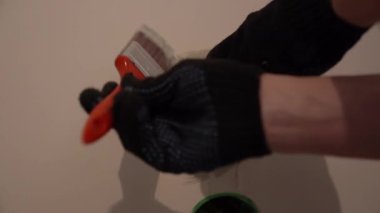 Priz açıklarının yakınındaki duvarları fırçayla boyamak. Daire tadilatı, elektrik bağlantısına hazırlık ve plastik prizlerin kurulumu. Yüksek kalite 4k görüntü