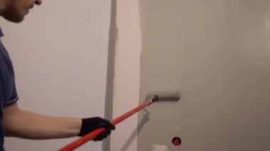 Modaya uygun gri renk. Gri bir şeridi silindirle uygulamak. Dairede minimalist yenileme. Yüksek kalite 4k görüntü