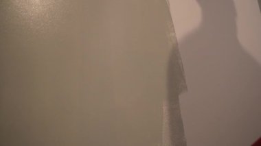 Duvarın alt tarafındaki manzarada, tamirci duvarları, mükemmel bir duvar resmi için kazık rulosu ile boyuyor. Tepeden tırnağa patinaj hareketi. Yüksek kalite 4k görüntü