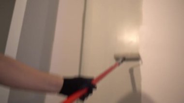 Duvarları boya rulosuyla griye boyayan bir profesyonel. Daire boyama, yenileme. Kopyalanacak bir yer var. Yüksek kalite 4k görüntü
