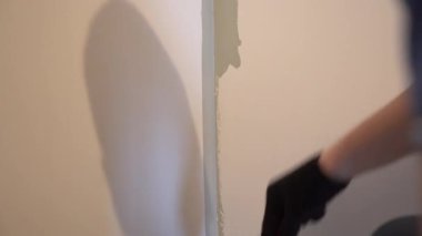 Köşenin yüzeyi fırça kullanılarak boyayla boyanır. Üniformalı boya uygulaması için. Daire tadilatı. Duvar boyama işlemi. Yüksek kalite 4k görüntü