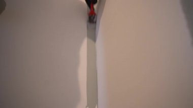 Köşenin yüzeyi fırça kullanılarak boyayla boyanır. Üniformalı boya uygulaması için. Daire tadilatı. Duvar boyama işlemi. Yüksek kalite 4k görüntü