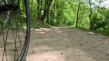 Bir bisiklet tekerleğinin altından, toprak bir yolda giderken