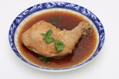 Tatlı kahverengi soslu haşlanmış tavuk, beyaz izole bir arka planda bir kasede. Tayland yemeği. Üst görünüm.