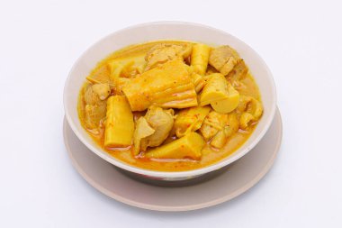 Domuz göbekli Güney ekşi çorba ve beyaz izole arka planda bir kasede korunmuş bambu filizleri. Tayland-Güney yemekleri. Üst görünüm.