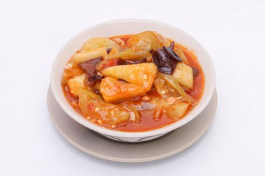 Kızarmış tatlı ve ekşi sos, beyaz bir tabakta sebzelerle birlikte, izole edilmiş beyaz bir arka planda. Tayland yemeği. Üst görünüm.