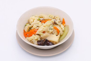 Kızarmış sebzeleri istiridye sosuyla karıştırıp beyaz bir kabın içinde, izole edilmiş beyaz bir arka planda. Tayland yemeği. Üst görünüm.