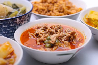Domuz etli Panaeng Curry. Kırmızı köri ezmeli M ve Tayland yemeği setindeki bir kasede hindistan cevizi sütü. Üst görünüm.