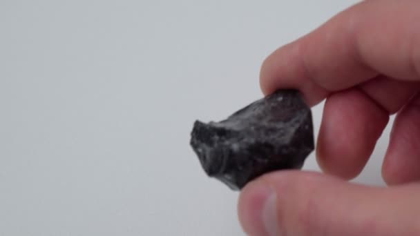 Schwarzer Obsidianstein Auf Weißem Hintergrund Naturglas Edelstein Aus Schwarzem Mineral — Stockvideo