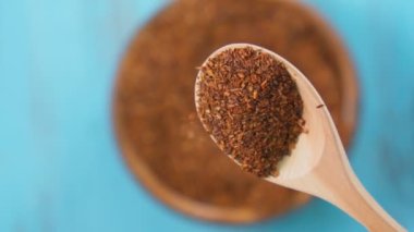 Bir yığın kırmızı kuru rooibos sağlıklı geleneksel organik çay kaşıkta. Seçici odaklanma. Yavaş çekim