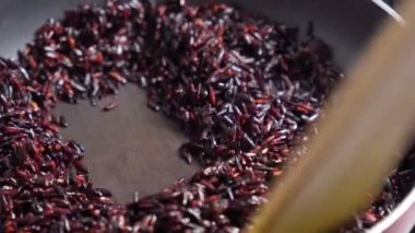 Cooking brown rice in water close-up. Organic natural ingredients for a healthy diet. Selective focus.