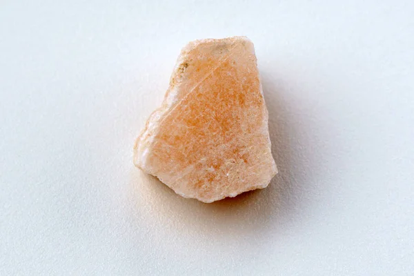 An unworked fragment of red gypsum, white background