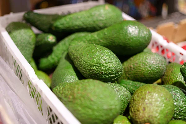 Stock image Fresh avocado fruits on the shelves of the hypermarket, selective focus. Goods on a supermarket showcase.