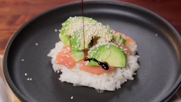 寿司ワッフルは料理プロセスです カリカリの米ワッフルとサーモン キュウリ アボカドを振りかけた料理のトレンド スローモーション — ストック動画