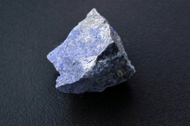 Raw mineral dumortierite is bluish in color on black background. clipart