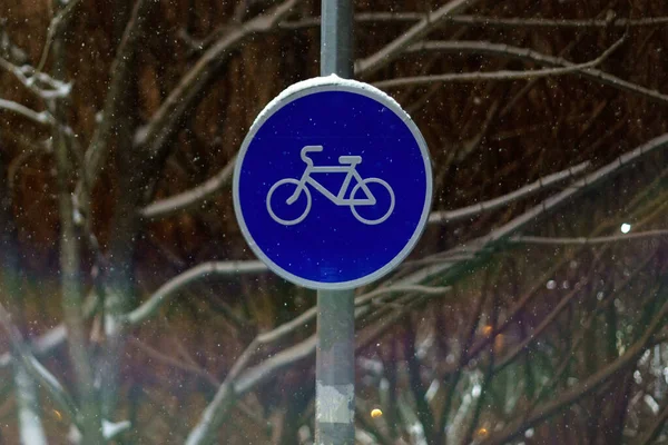 Round bicycle sign transit for bicycles. Bicycle road sign. Winter, night
