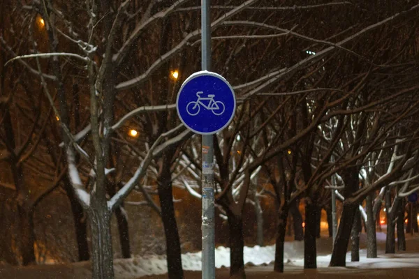 Round bicycle sign transit for bicycles. Bicycle road sign. Winter, night. Selective focus