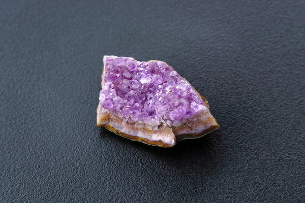 Crystal stone is a mineral. Purple rough amethyst quartz crystals, on black background