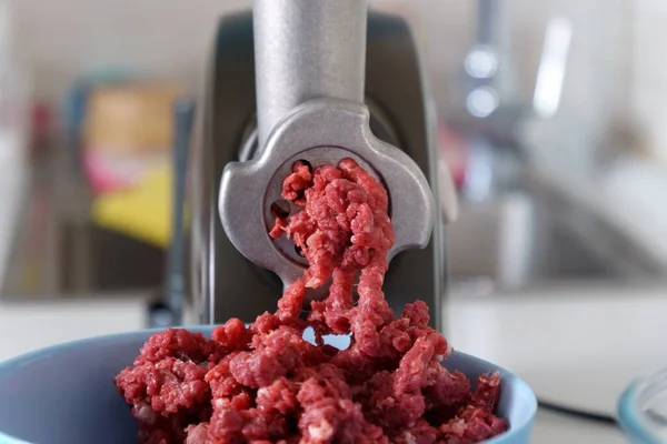 Process of preparing forcemeat by means of a meat grinder. Raw meat. Electric mincer machine