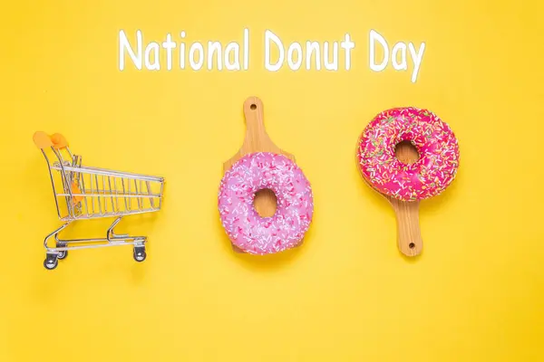 stock image National Donut Day, donuts with pink sugar glaze and sprinkled with colorful pastry crumbs, on a yellow background.