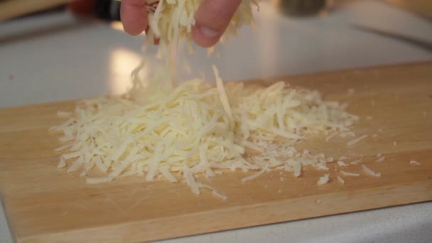 すりおろしたチーズを閉じます 男はチーズを手に取り 振りかける スローモーション — ストック動画