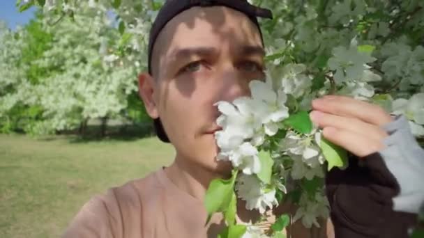 Чоловік Чхає Стоїть Поруч Квітами Парку Поняття Симптоми Алергії Пилок — стокове відео