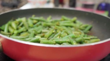 Kızartma tavasında yeşil fasulye pişirmek. Biyolojik yeşil fasulye. Sağlıklı ev yemekleri hazırlıyorum. Seçici odak
