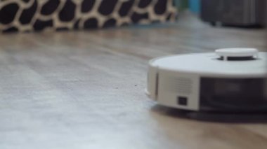 Beyaz robot elektrikli süpürge daireyi otomatik olarak temizliyor. Akıllı Ev seçici odak