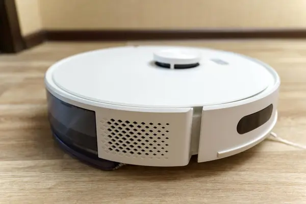 Modern white robotic vacuum cleaner. Self Drive Cleaning Robot. Floor Cleaning System. Selective focus