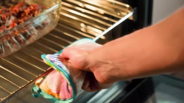厨师的手 把一盘美味的肉丸子滑入厨房烤箱的炽热之中 — 图库视频影像