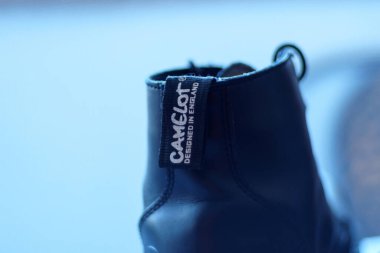 Önemli bir Camelot logosu etiketi olan bir ayakkabı. Ayakkabı merkezi odak noktasıdır, marka açıkça gösterilir..