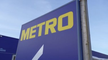 Tyumen, Rusya-02 Mart 2024: Metro tabelası hareketli bir şehrin arka planında belirgin bir şekilde duruyor.