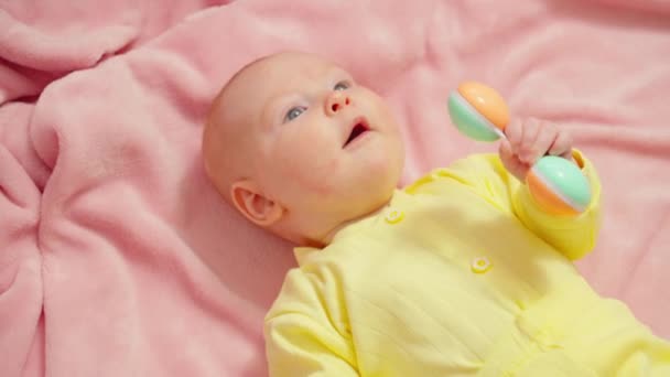 ピンクのブランケットに黄色のアウトフィットの赤ちゃん 3か月の小さな子供 — ストック動画
