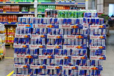 Tyumen, Rusya-02 Mart 2024: Müşterileri çekmek için düzgünce istiflenmiş ve organize edilmiş Red Bull enerji içeceği kutularıyla dolu bir mağazada görüntüleme.