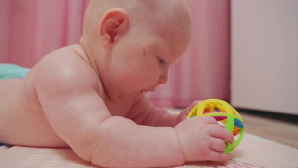 Bébi Földön Fekve Örömmel Fedezi Fel Játékot Kuncogva Kinyújtózva Csecsemők — Stock videók