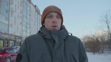 Kışın alacakaranlıkta soğuğa göğüs geren adam.