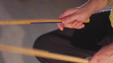 Altın bagetler, sanatsal enerjiyle dolu canlı bir stüdyo ortamında yaratıcılık ve ritmi harmanlayan parlak kırmızı sekizgen bir yüzey üzerinde asılı duruyor..