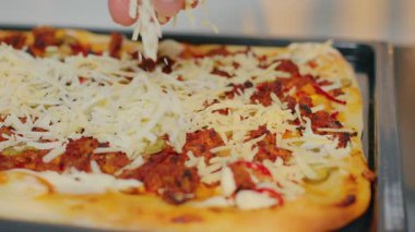 Lezzetli et, taze sebze ve sıcak bir mutfak ortamında erimiş peynirli ev yapımı pizza.