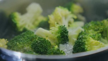 Mutfakta sağlıklı bir yemek hazırlamak için kaynar suda brokoli pişirmek.