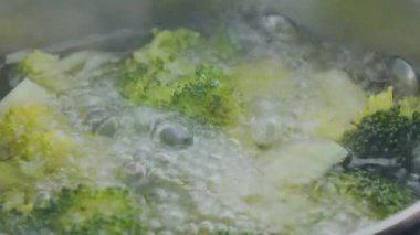 Mutfakta sağlıklı bir yemek hazırlamak için kaynar suda brokoli pişirmek.